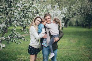 Parents hugging their children in nature.