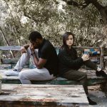 Man and woman sitting on the bench looking sad