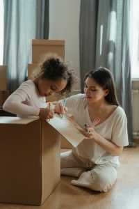 A mother and daughter packing boxes for a move.