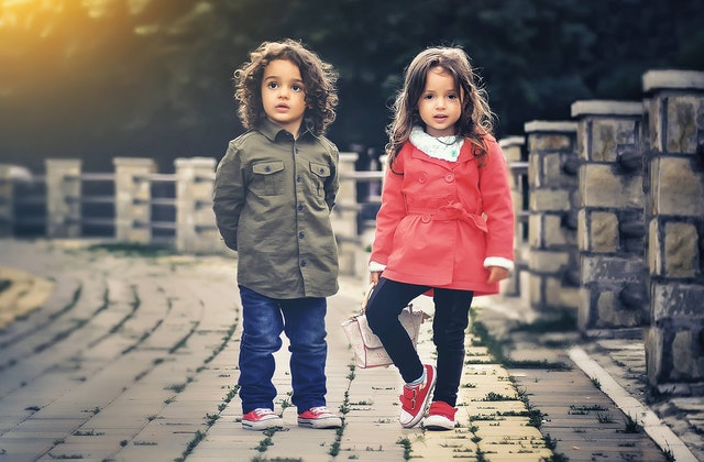 Children standing near a fence.