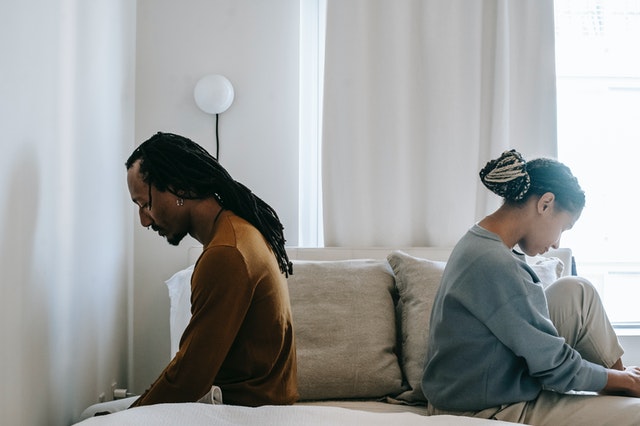 A couple sitting on a bed