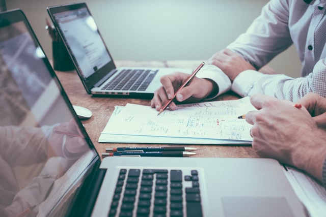 Two people sitting at a desk and analyzing finances.