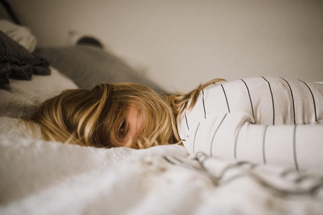 A woman lying face-down on a bed