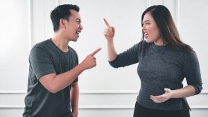 A couple pointing fingers at each other during a heated argument signs of divorce