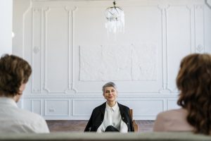 A female mediator facing the divorcing couple during divorce mediation.