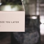 A "see you later" sign on a white canvas with blurred background.