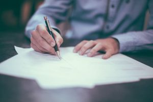 Person signing some papers. 