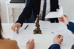 Couple signing divorce papers in front of a mediator. 