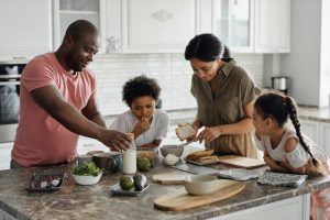 Family of four making a meal together on a kitchen island