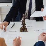 Couple signing divorce papers with their attorney