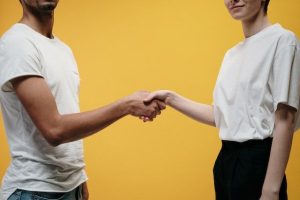 Man and woman shaking hands and healing through divorce mediation.