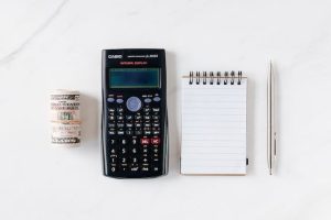 A calculator, a notepad, some cash, and a pen